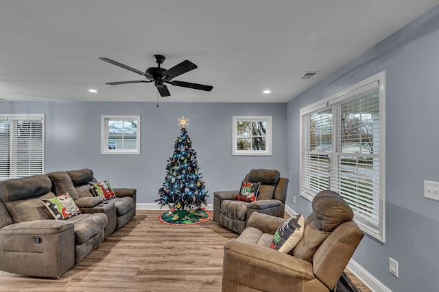 living room featuring ceiling fan, light hardwood / wood-style flooring, and a healthy amount of sunlight