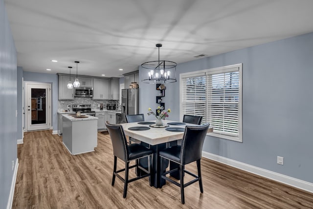 dining room with a notable chandelier and light wood-type flooring