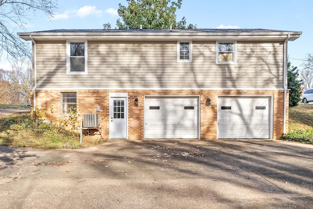 back of house with central AC and a garage