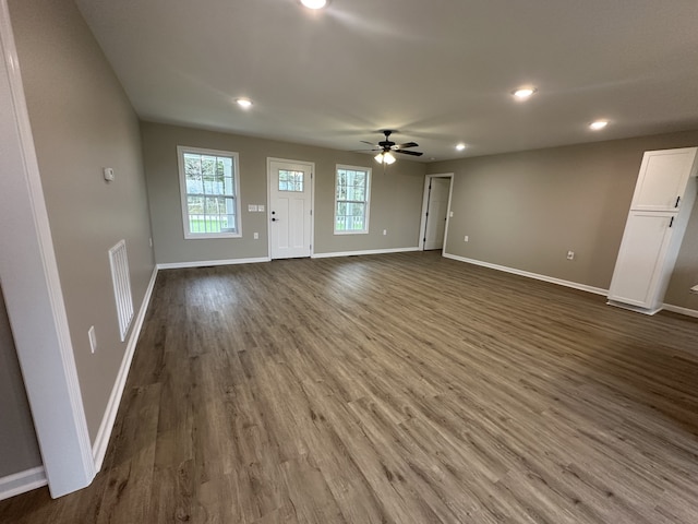 unfurnished living room featuring ceiling fan and dark hardwood / wood-style flooring