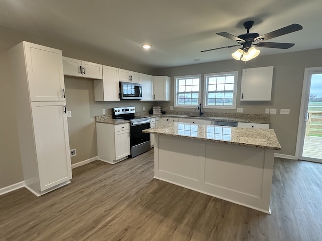 kitchen with ceiling fan, sink, a center island, white cabinets, and appliances with stainless steel finishes