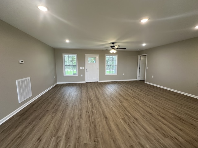 unfurnished living room with dark hardwood / wood-style flooring and ceiling fan