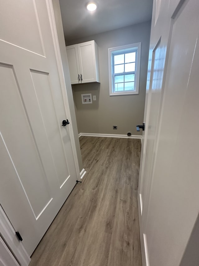 washroom with cabinets, light hardwood / wood-style flooring, washer hookup, and hookup for an electric dryer