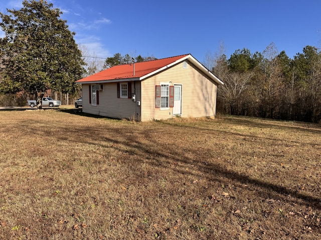 view of side of home with a yard