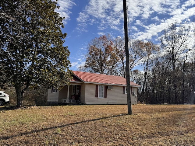 view of property exterior featuring a lawn and a wall mounted AC