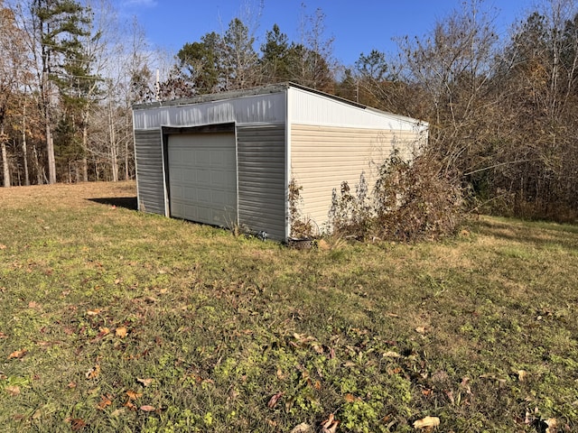 view of outdoor structure with a lawn and a garage