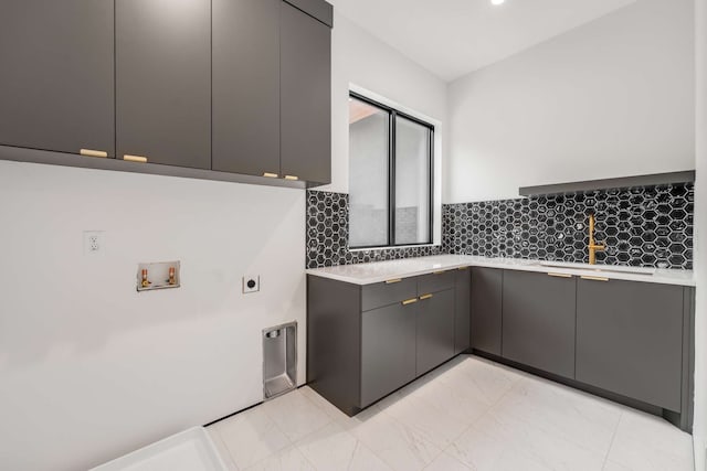 kitchen featuring backsplash, gray cabinetry, and sink