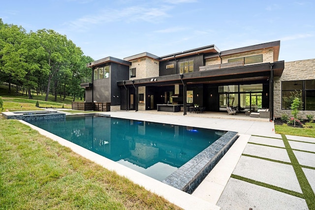 view of swimming pool featuring outdoor lounge area, exterior kitchen, a yard, and a patio