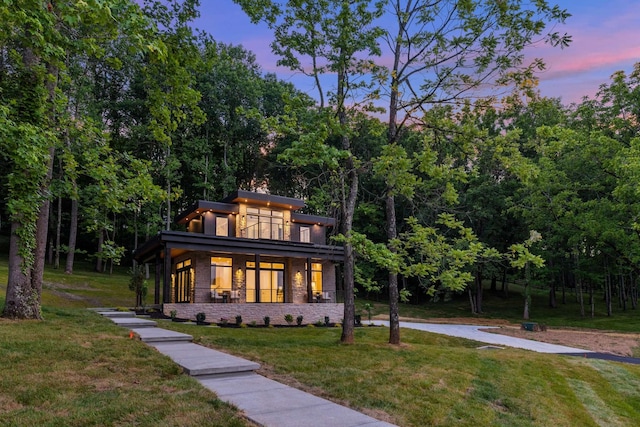 view of front of property with a lawn and a balcony