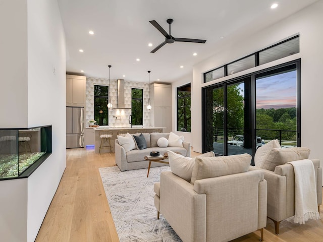 living room featuring light wood-type flooring and ceiling fan