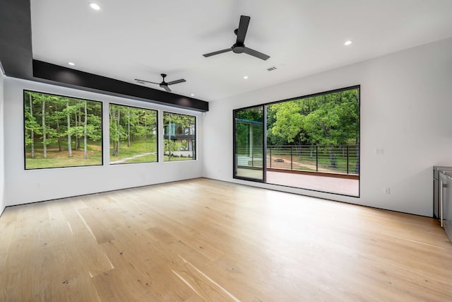 empty room with ceiling fan and light hardwood / wood-style floors