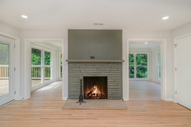 unfurnished living room with a fireplace and light hardwood / wood-style floors