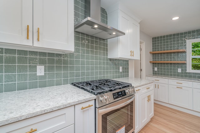 kitchen with white cabinetry, stainless steel range with gas stovetop, light stone counters, tasteful backsplash, and wall chimney exhaust hood