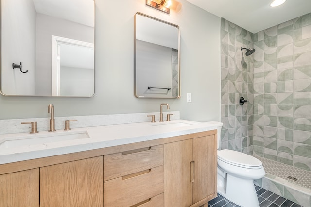 bathroom featuring tiled shower, vanity, toilet, and tile patterned floors