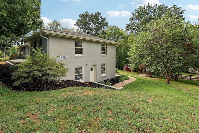 rear view of house featuring a yard