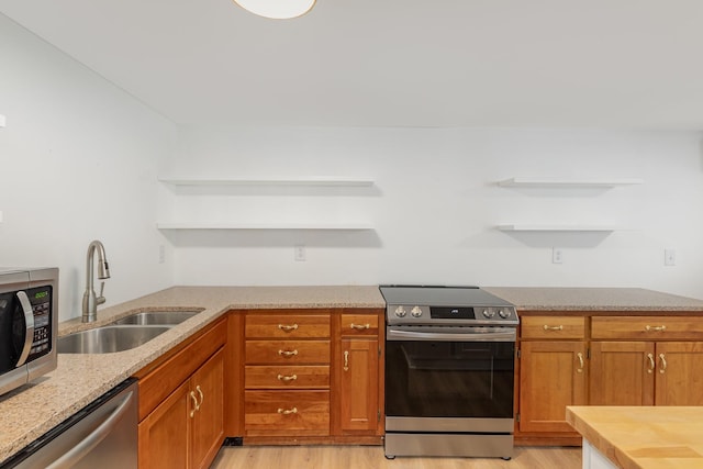 kitchen featuring stainless steel appliances, sink, and light hardwood / wood-style floors