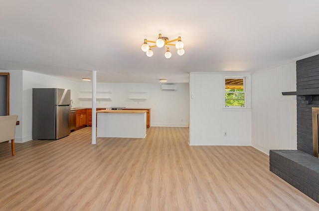 living room featuring a brick fireplace, light hardwood / wood-style flooring, and a wall mounted AC