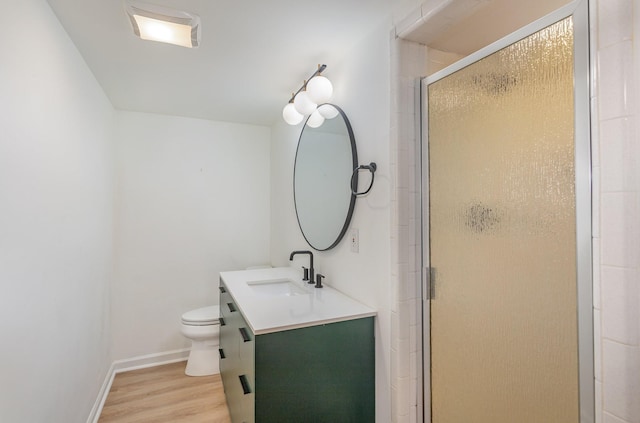 bathroom featuring hardwood / wood-style flooring, vanity, toilet, and a shower with door