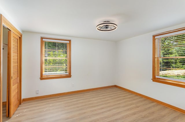 unfurnished bedroom with a closet and light hardwood / wood-style flooring