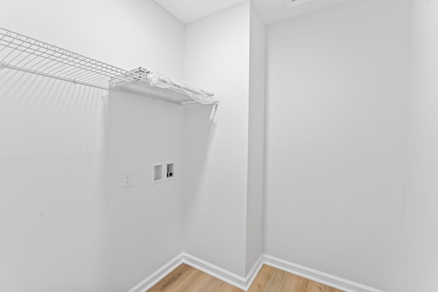 clothes washing area with washer hookup, laundry area, light wood-style flooring, and baseboards