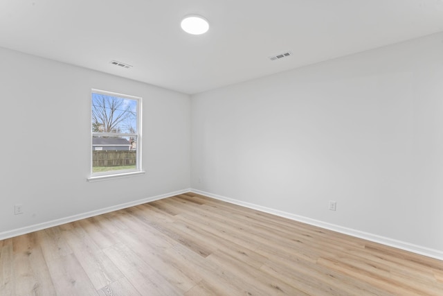 empty room with baseboards, visible vents, and light wood-style floors