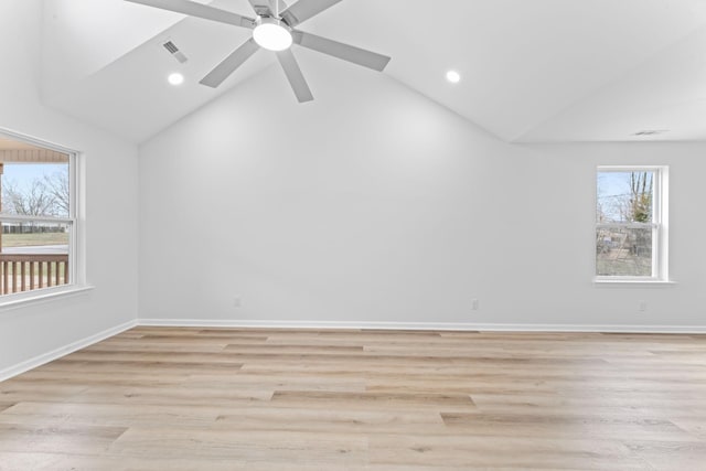 empty room featuring lofted ceiling, light wood-style floors, and visible vents