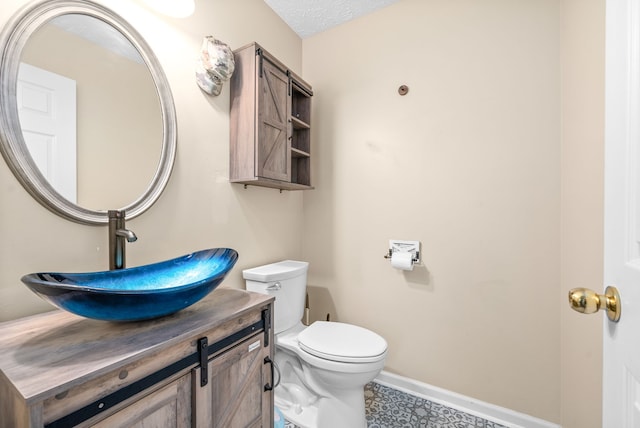 bathroom with vanity, a textured ceiling, and toilet