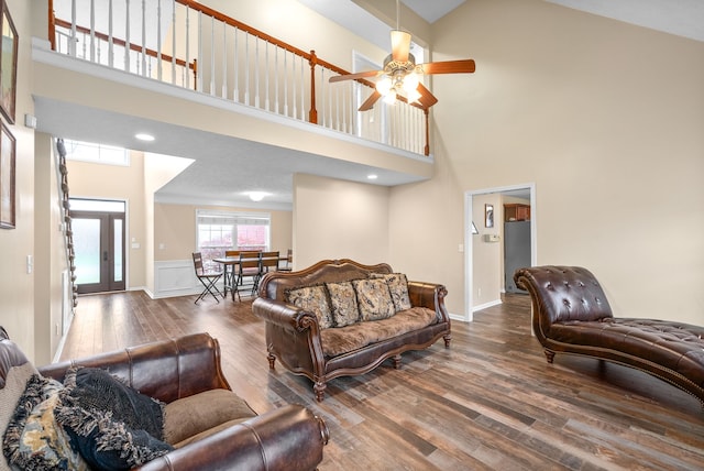 living room with ceiling fan, high vaulted ceiling, and dark wood-type flooring