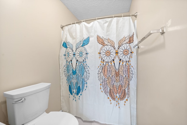 bathroom featuring a textured ceiling and toilet