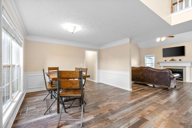 dining room featuring a textured ceiling, dark hardwood / wood-style floors, and crown molding