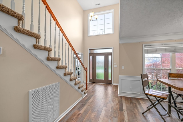 entrance foyer featuring a chandelier, a wealth of natural light, wood-type flooring, and a textured ceiling