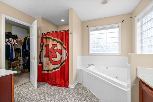 bathroom with plus walk in shower, vanity, and a wealth of natural light