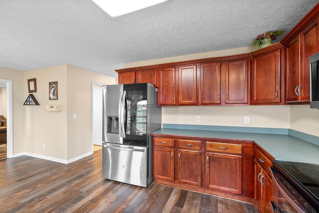 kitchen with a textured ceiling, stainless steel appliances, and dark hardwood / wood-style floors