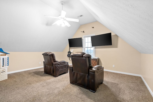 carpeted home theater room with a textured ceiling, ceiling fan, and lofted ceiling