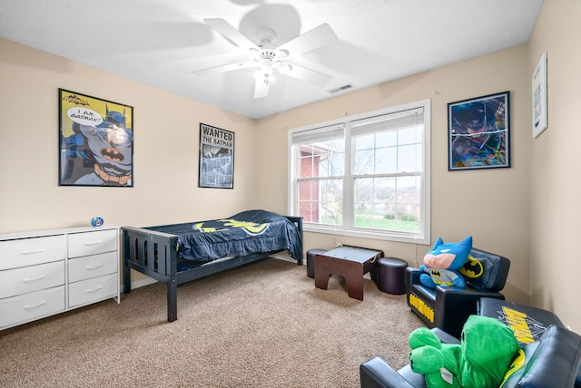 carpeted bedroom featuring a textured ceiling and ceiling fan