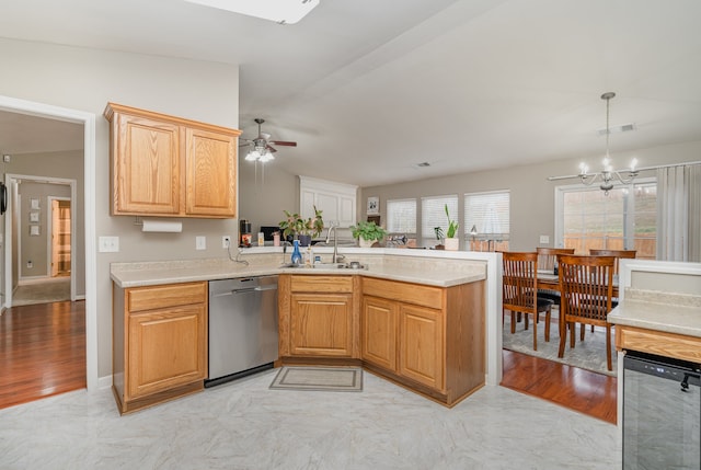 kitchen with kitchen peninsula, light wood-type flooring, stainless steel dishwasher, sink, and lofted ceiling