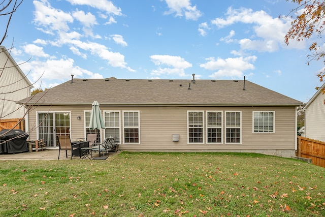 rear view of property featuring a patio area and a lawn