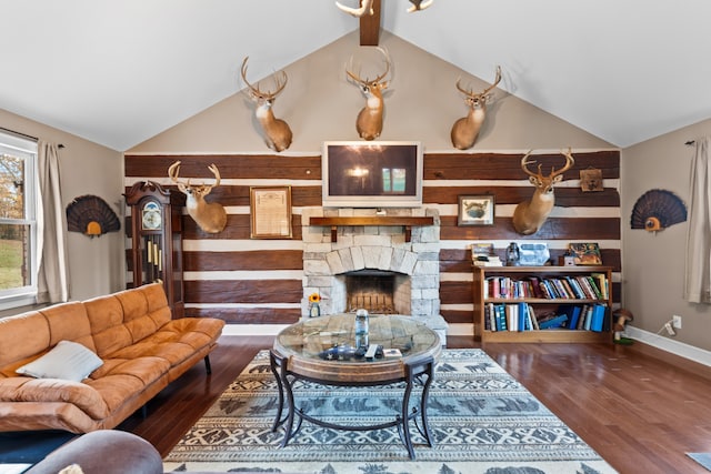 living room with wood-type flooring, a stone fireplace, high vaulted ceiling, and beam ceiling