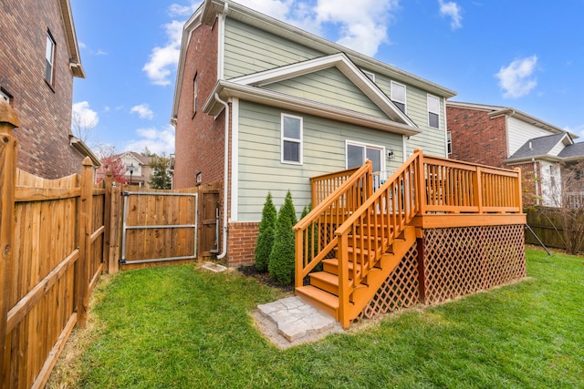 back of property with a deck and a lawn