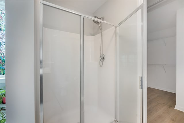 bathroom featuring hardwood / wood-style floors and a shower with door