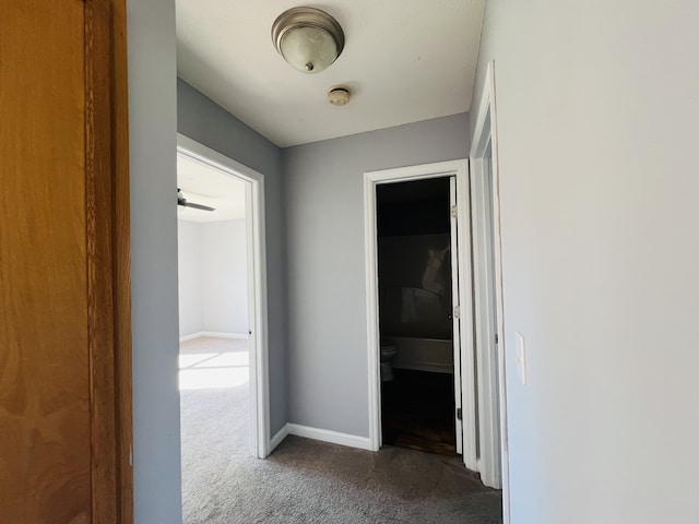 corridor featuring dark colored carpet