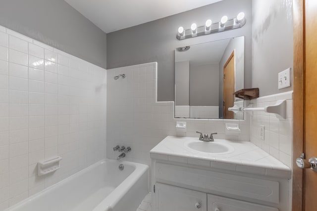 bathroom featuring vanity, tile walls, and tiled shower / bath