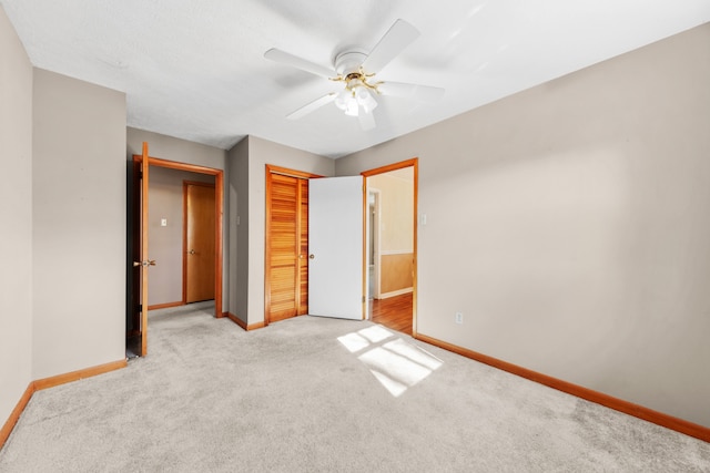 unfurnished bedroom featuring ceiling fan, light carpet, and a closet