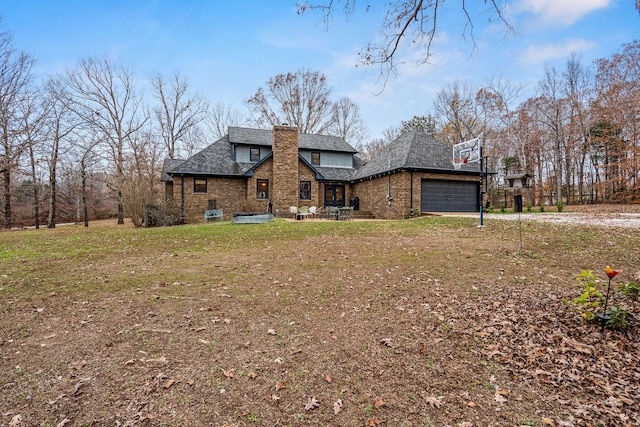 rear view of house with a garage and a yard