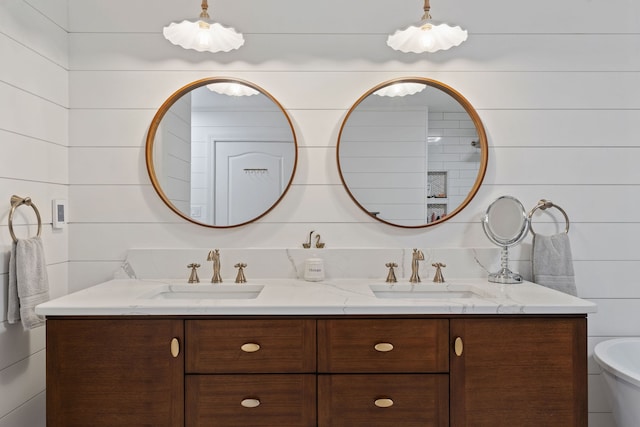 bathroom featuring vanity and wood walls