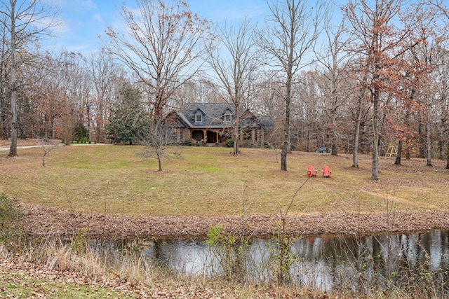 rear view of property with a yard and a water view