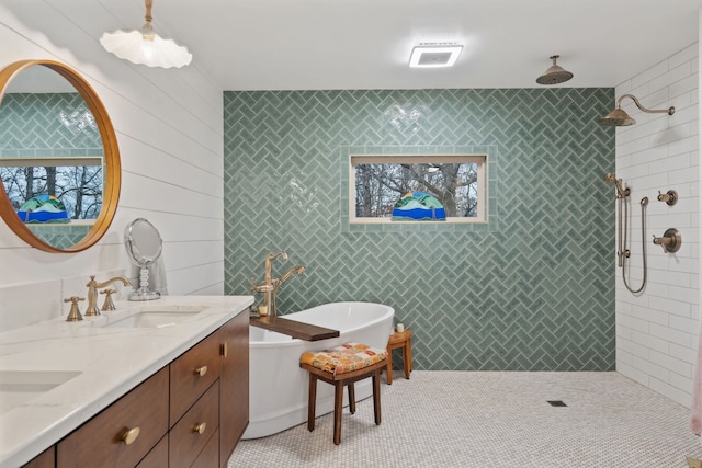 bathroom with tile patterned flooring, vanity, tile walls, and shower with separate bathtub