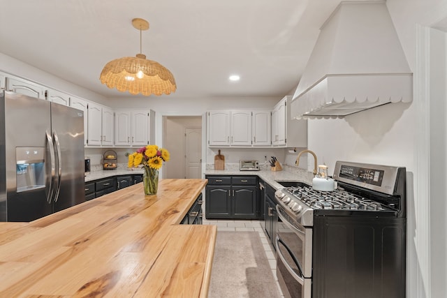 kitchen featuring butcher block counters, sink, hanging light fixtures, white cabinets, and appliances with stainless steel finishes