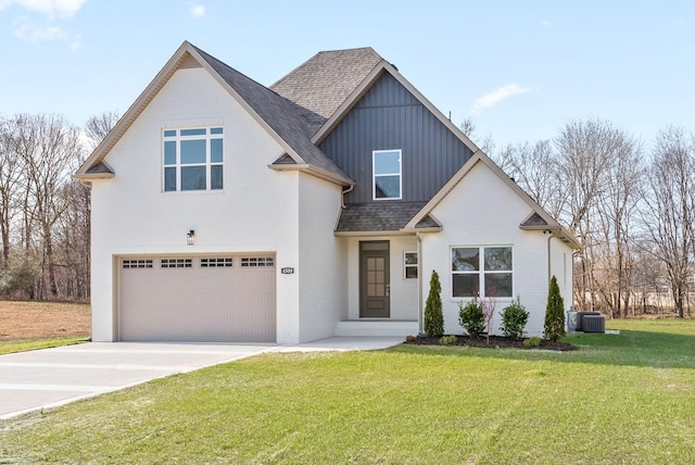 view of front of property featuring cooling unit, a front yard, and a garage