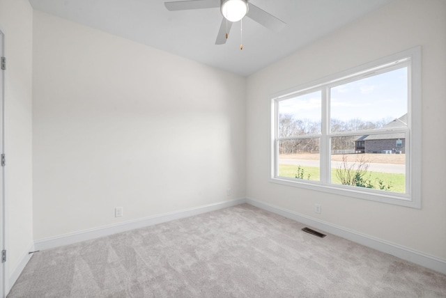 spare room with ceiling fan and light colored carpet